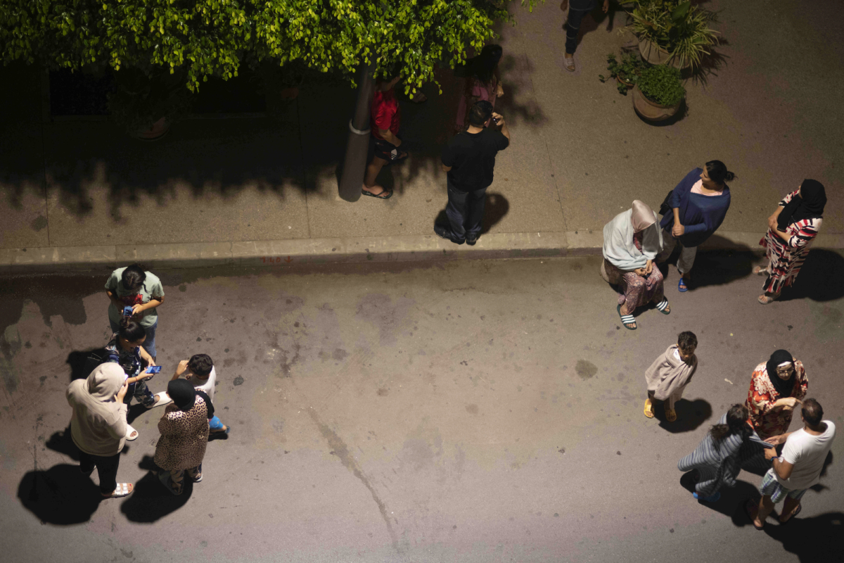 Người dân trú ẩn và kiểm tra tin tức trên điện thoại di động sau trận động đất ở Rabat, Morocco, hôm 08/09/2023. (Ảnh: Mosa’ab Elshamy/AP Photo)