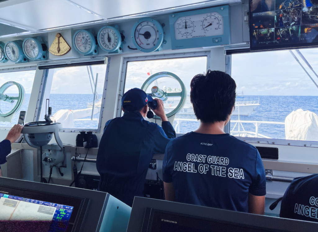 Một thành viên của Lực lượng Tuần duyên Philippines sử dụng ống nhòm để kiểm tra tàu Hải cảnh Trung Quốc trong nhiệm vụ tiếp tế cho những binh lính đang đồn trú trên một tàu bị mắc cạn ở Biển Đông của Philippines hôm 08/09/2023. (Ảnh: Jay Ereno/Reuters)