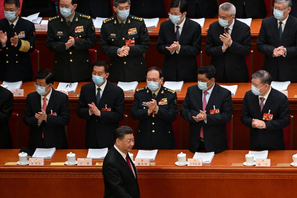 Các quan chức đại diện, bao gồm Bộ trưởng Quốc phòng Trung Quốc Ngụy Phượng Hòa (thứ 3 từ trái sang), hoan nghênh lãnh đạo Trung Quốc Tập Cận Bình (phía dưới) đến dự phiên khai mạc Đại hội Đại biểu Nhân dân Toàn quốc (NPC) tại Đại lễ đường Nhân dân ở Bắc Kinh hôm 05/03/2023. (Ảnh: Noel Celis/AFP qua Getty Images)