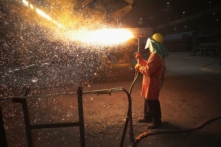 Một nhân viên cắt tấm thép mới đúc tại nhà máy thép NLMK Indiana ở Portage, Indiana, hôm 15/03/2018. Các  chuyên gia cho biết, các chiến thuật sản xuất quá mức và bán phá giá của Trung Quốc đã khiến ngành thép Hoa Kỳ mất hàng ngàn việc làm. (Ảnh: Scott Olson/Getty Images)
