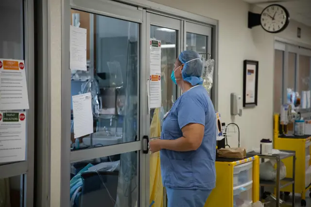 Một chuyên gia chăm sóc sức khỏe chuẩn bị vào phòng bệnh nhân trong một bức ảnh tư liệu. (Ảnh: Megan Jelinger/AFP qua Getty Images)