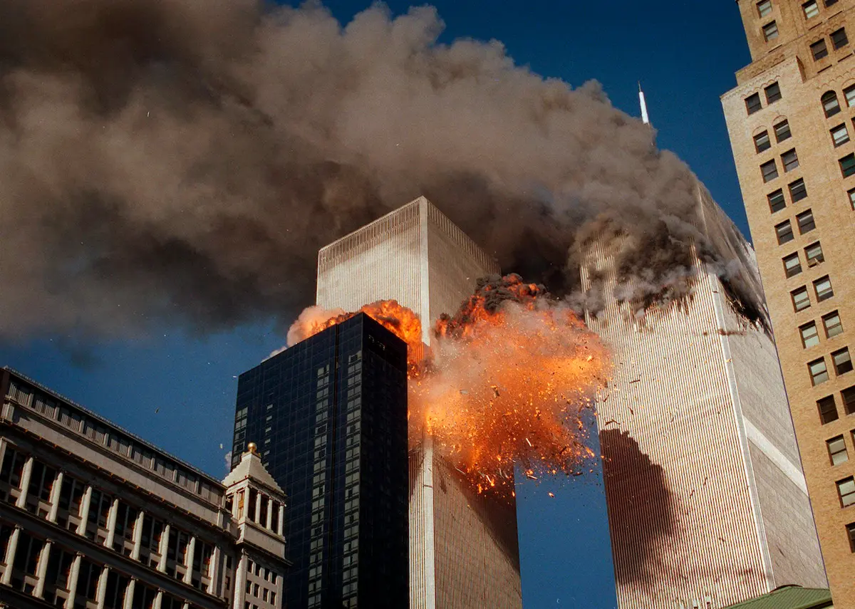 Khói bốc cuồn cuộn từ một trong những tòa tháp của Trung tâm Thương mại Thế giới khi ngọn lửa và các mảnh vỡ của tòa tháp thứ hai nổ tung, ở thành phố New York, vào ngày 11/09/2001. (Ảnh: Chao Soi Cheong/AP Photo)