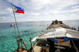 Quốc kỳ Philippines tung bay trên tàu BRP Sierra Madre, một tàu Hải quân Philippines cũ nát bị mắc cạn từ năm 1999 và trở thành một đơn vị quân sự của Philippines trên Bãi Cỏ Mây (Bãi cạn Second Thomas) đang tranh chấp, một phần của Quần đảo Trường Sa, ở Biển Đông vào ngày 29/03/2014. (Ảnh: Erik De Castro/Reuters)