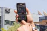 Một phụ nữ Israel sử dụng iPhone trước tòa nhà cung cấp địa điểm cho tập đoàn NSO của Israel, ở Herzliya, gần Tel Aviv, vào ngày 28/08/2016. (Ảnh: Jack Guez/AFP qua Getty Images)