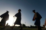 Các học sinh cuối cấp trung học tiến đến sân bóng khi mặt trời bắt đầu lặn để dự lễ tốt nghiệp ở Saltillo, Mississippi, vào ngày 27/06/2020. (Ảnh: Thomas Wells/Nhật báo The Northeast Mississippi qua AP, Tư liệu)