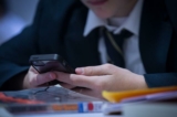 Một học sinh sử dụng điện thoại di động của mình để tra cứu thông tin trong giờ học tiếng Anh tại Học viện Quốc tế Ridings Federal Winterbourne ở Winterbourne gần Bristol vào ngày 26/02/2015. (Ảnh: Matt Cardy/Getty Images)