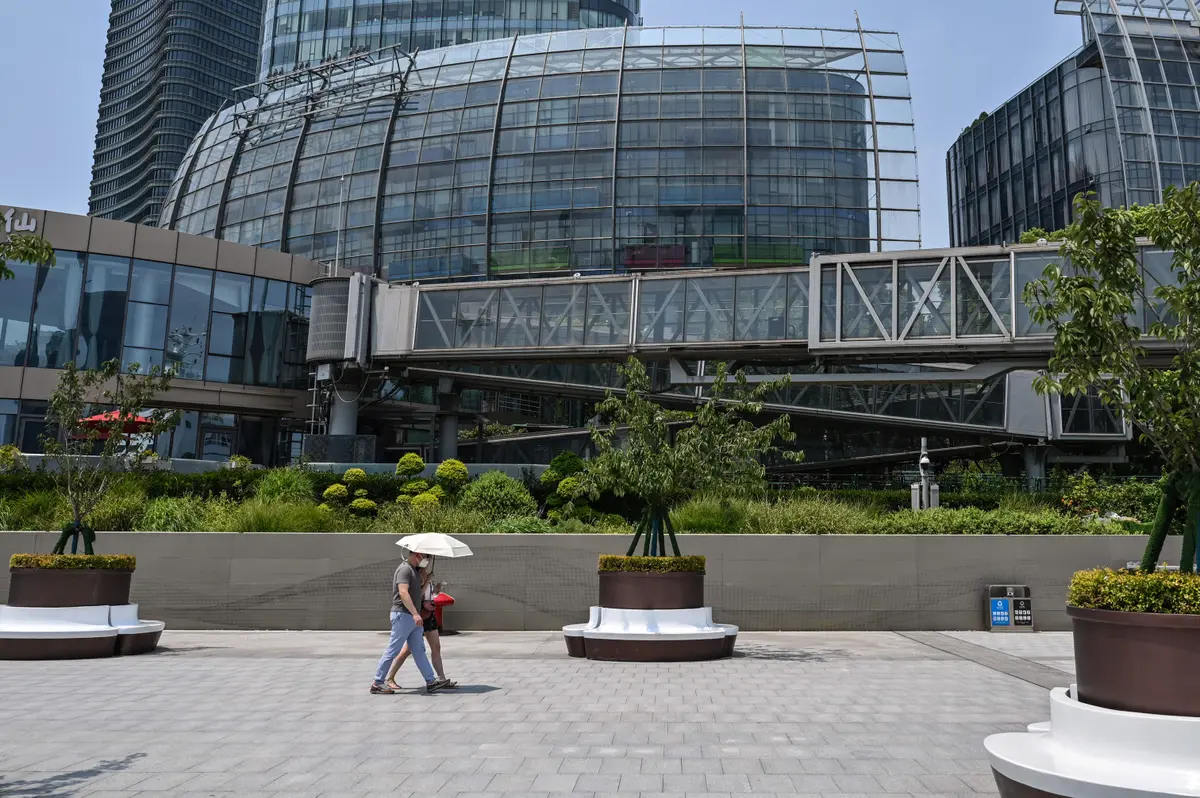 Biển hiệu công ty đã bị gỡ bỏ (bên trái trên cùng) trong góc nhìn tổng thể của tòa nhà Trung tâm Evergrande không có người bên trong, ở Thượng Hải hôm 27/07/2022. (Ảnh: Hector Retamal/AFP qua Getty Images)