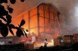 Người dân chứng kiến vụ hỏa hoạn tại một nhà máy của công ty sản xuất bóng golf Launch Technologies ở huyện Bình Đông, miền nam Đài Loan hôm 22/09/2023. (Ảnh: FTV qua AP)