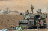 Các binh sĩ Israel đang chuẩn bị xung quanh xe bọc thép, ảnh chụp vào ngày 10/10/2023. (Ảnh: Alexi J. Rosenfeld/Getty Images)