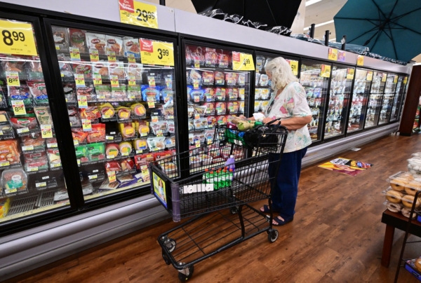 Một người phụ nữ kiểm tra các mặt hàng từ khu vực đông lạnh khi đi mua hàng bách hóa tại một siêu thị ở Alhambra, California, hôm 13/07/2022. (Ảnh: Frederic J. Brown/AFP qua Getty Images)