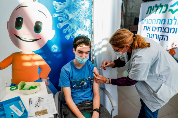 Một thiếu niên nhận được một mũi vaccine Pfizer-BioNtech COVID-19 tại Clalit Health Services ở Tel Aviv, Israel, vào ngày 23/01/2021. (Ảnh: Jack Guez/AFP qua Getty Images)