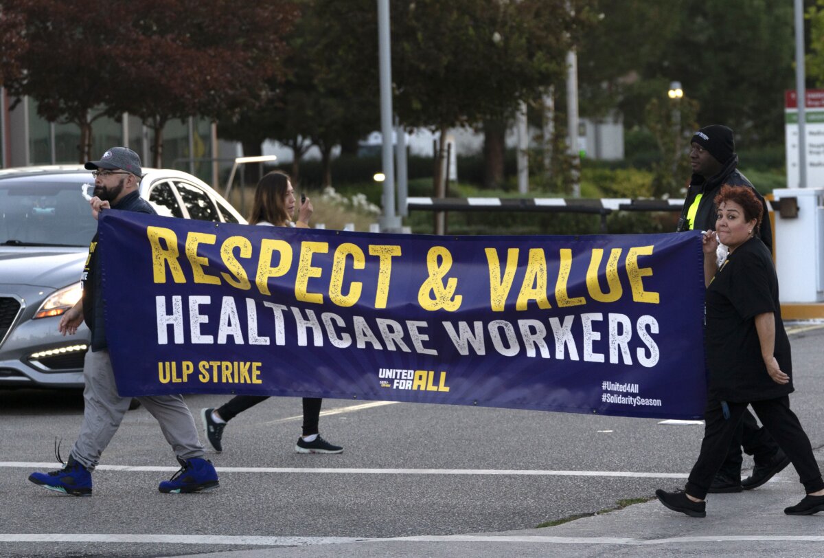 Các nhân viên của Kaiser Permanente giương biểu ngữ bên ngoài bệnh viện trong cuộc đình công ở khu vực thành phố Panorama của Los Angeles hôm 04/10. (Ảnh: Richard Vogel/AP)