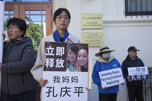 Cô Lưu Chỉ Đồng (Liu Zhitong) cầm bức ảnh của mẹ cô trong một sự kiện tại Lãnh sự quán Trung Quốc ở San Francisco hôm 19/06/2023. Tấm bảng viết: “Ngay lập tức thả mẹ tôi Khổng Khánh Bình.” (Ảnh: Được đăng dưới sự cho phép của Minghui.org)