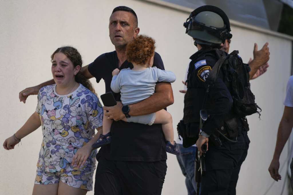Các nhân viên cảnh sát Israel di tản một gia đình khỏi địa điểm bị trúng hỏa tiễn từ Dải Gaza, ở Ashkelon, miền nam Israel, hôm 07/10/2023. (Ảnh: AP Photo/Tsafrir Abayov)