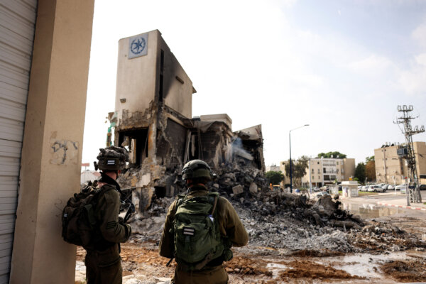 Các binh sĩ Israel quan sát đống tàn tích của đồn cảnh sát, nơi diễn ra trận chiến sau vụ xâm nhập hàng loạt của các tay súng Hamas từ Dải Gaza, ở Sderot, Nam phần Israel, hôm 08/10/2023 (Ảnh: Reuters/Ronen Zvulun)
