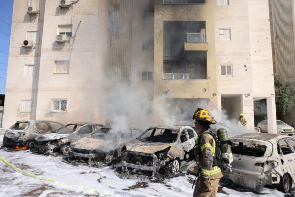 Các đội cứu hỏa Israel dập lửa tại bãi đậu xe bên ngoài một tòa nhà dân sự sau một vụ tấn công bằng hỏa tiễn từ Dải Gaza ở thành phố Ashkelon tại phía nam Israel hôm 07/10/2023. (Ảnh: Ahmad Gharabli/AFP qua Getty Images)
