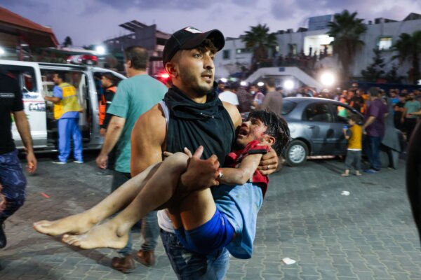 Một người đàn ông bế một đứa trẻ vào bệnh viện Al-Shifa ở thành phố Gaza, hôm 11/10/2023. (Ảnh: Mohammed Abed/AFP qua Getty Images)