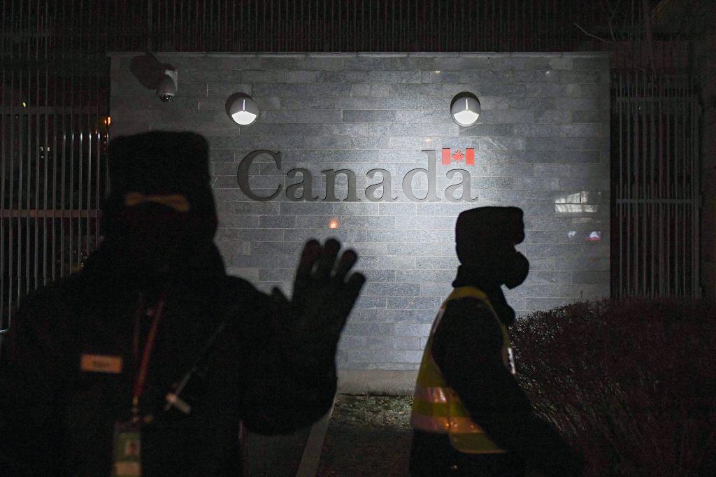 Một người bảo vệ cố gắng ngăn bị chụp hình khi đi tuần tra bên ngoài Đại sứ quán Canada ở Bắc Kinh vào ngày 14/01/2019. (Ảnh: Greg Baker/AFP qua Getty Images)