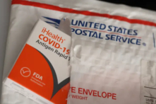 Các bộ xét nghiệm nhanh kháng nguyên COVID-19 miễn phí nhãn hiệu iHealth từ chính phủ liên bang nằm trên phong bì của Bưu điện Hoa Kỳ sau khi được giao tại San Anselmo, California, vào ngày 04/02/2022. (Ảnh: Justin Sullivan/Getty Images)