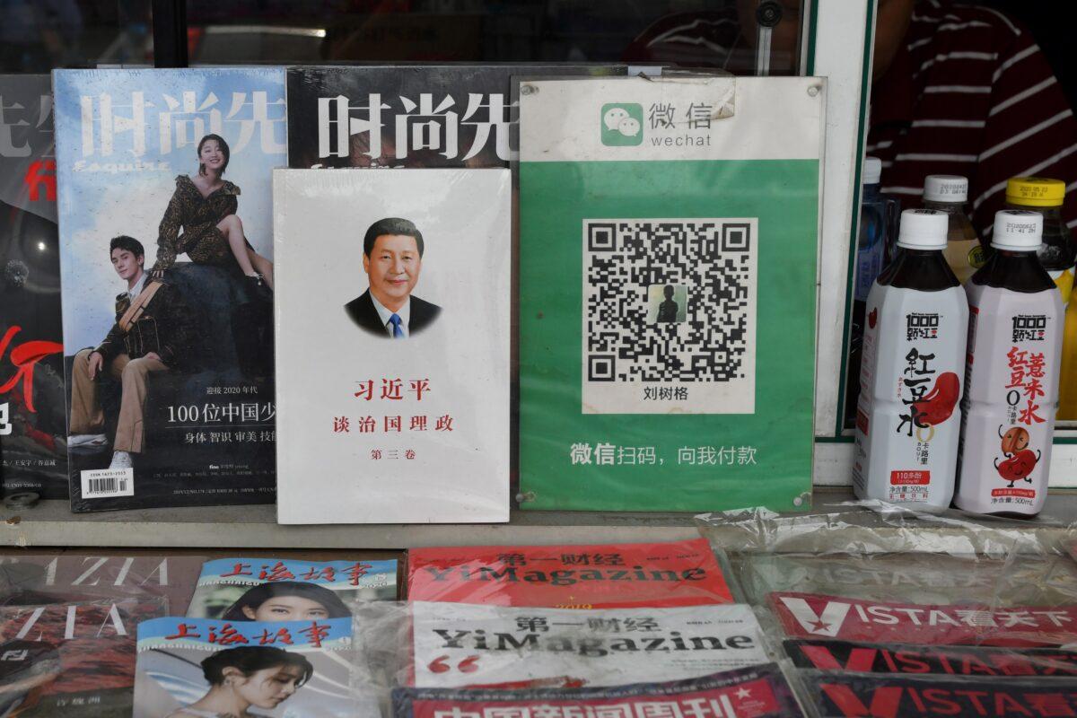 Mã thanh toán QR cho Wechat Pay (bên phải) bên cạnh cuốn sách về lãnh đạo Trung Quốc Tập Cận Bình, có tựa đề “Tập Cận Bình: Đàm luận về quản trị Trung Quốc” tại một sạp báo ở Bắc Kinh  hôm 18/09/2020. (Ảnh: Greg Baker/AFP qua Getty Images)