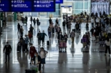 Các hành khách đang đi lại trong Phi trường Quốc tế Hồng Kông hôm 08/12/2022. (Ảnh: Isaac Lawrence/AFP qua Getty Images)