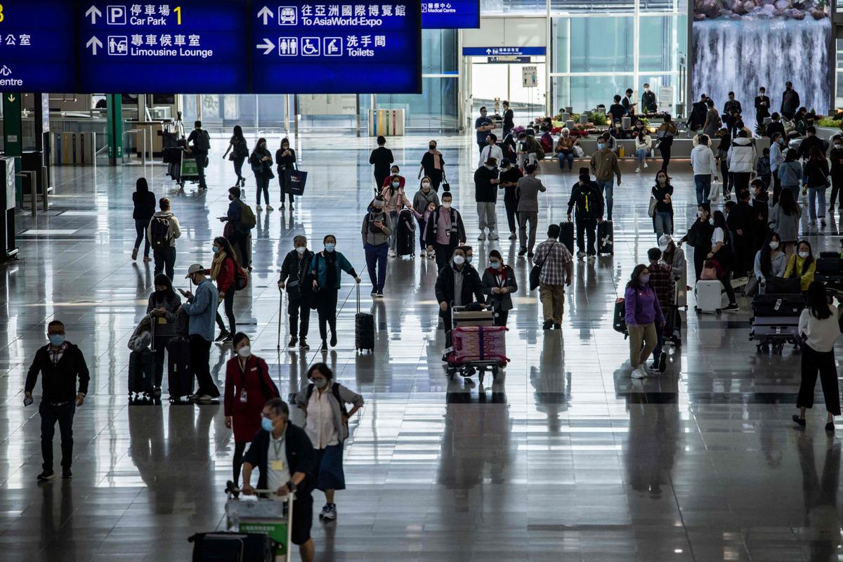 Các hành khách đang đi lại trong Phi trường Quốc tế Hồng Kông hôm 08/12/2022. (Ảnh: Isaac Lawrence/AFP qua Getty Images)
