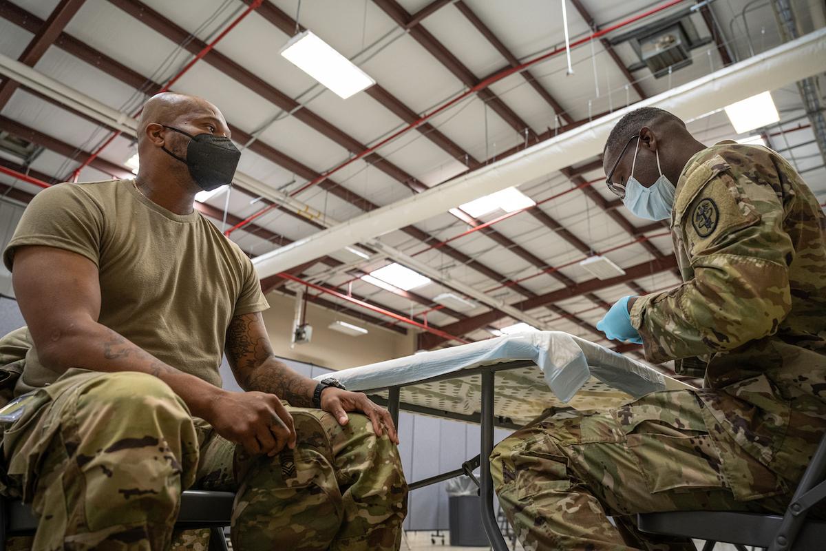 Hạ sĩ quan phụ trách NCOIC Trung sĩ Nhất Demetrius Roberson của Dịch vụ Y tế Dự phòng chuẩn bị chích vaccine COVID-19 cho một người lính ở Fort Knox, Kentucky, vào ngày 09/09/2021. (Ảnh: Jon Cherry/Getty Images)