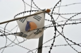 Lá cờ Nam Hàn treo trên hàng rào dây thép gai quân sự bay nhẹ theo gió tại công viên hòa bình Imjingak gần Khu Phi Quân sự (DMZ) phân chia hai miền Triều Tiên ở thành phố biên giới Paju vào ngày 16/04/2013. (Ảnh: Jung Yeon-je/AFP qua Getty Images)