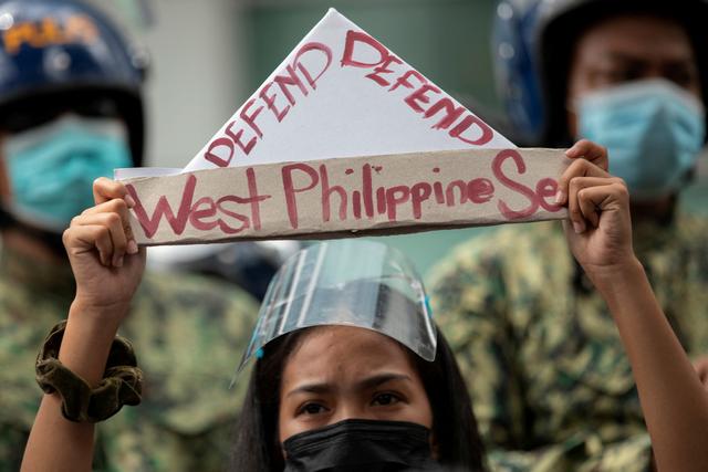 Một người biểu tình cầm chiếc thuyền giấy có dòng chữ “bảo vệ Biển Tây Philippine” trong cuộc biểu tình bên ngoài Lãnh sự quán Trung Quốc ở khu tài chính Manila, thủ đô Philippines, ngày 12/07/2021. (Ảnh: Eloisa Lopez/Reuters)