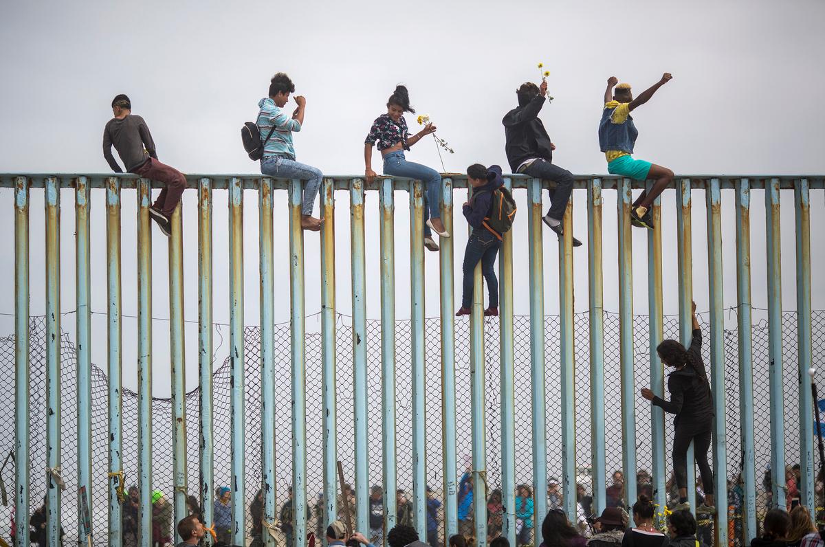 Những người nhập cư bất hợp pháp leo lên một đoạn hàng rào biên giới Hoa Kỳ-Mexico ở Tijuana, Mexico, vào ngày 29/04/2018. (Ảnh: David McNew/Getty Images)