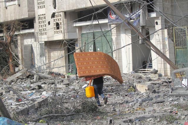 Người dân Palestine rời khỏi những căn nhà đã bị hư hại do các cuộc không kích của Israel ở thành phố Gaza, Gaza, hôm 10/10/2023. (Ảnh Ahmad Hasaballah/Getty Images)