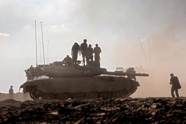 Binh sĩ Israel đứng trên xe tăng tại một cánh đồng gần kibbutz Beeri thuộc miền nam Israel, hôm 14/10/2023. (Ảnh: Thomas Coex/AFP qua Getty Images)