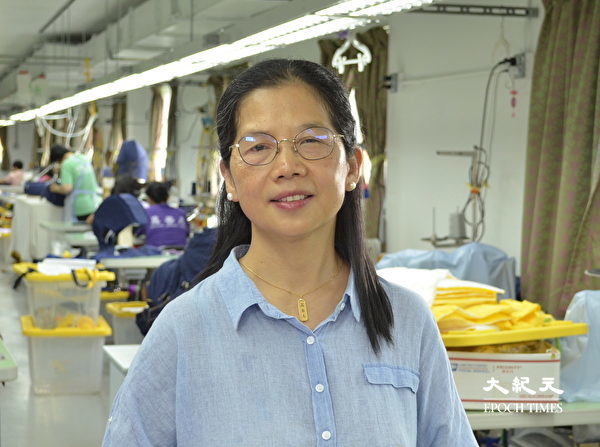Bà Quách Thiên Hoa (Guo Qianhua), thợ may tại nhà máy thời trang Shen Yun Dancer, giới thiệu các kỹ thuật được sử dụng để may áo khoác mùa đông kiểu mới. (Ảnh: Vu Lệ Lệ/Epoch Times)