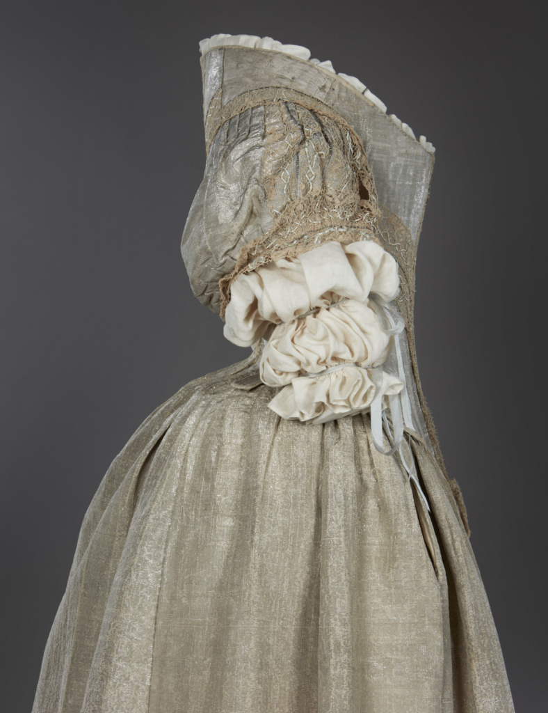 Chiếc váy có phần thân áo cứng làm từ phiến sừng ở hàm trên của cá voi (whalebone) và phần váy khâu tay từ lụa tơ tằm thượng hạng bện với sợi bạc thật. (Ảnh: © Tổ chức Historic Royal Palaces/Bảo tàng Thời trang Bath)