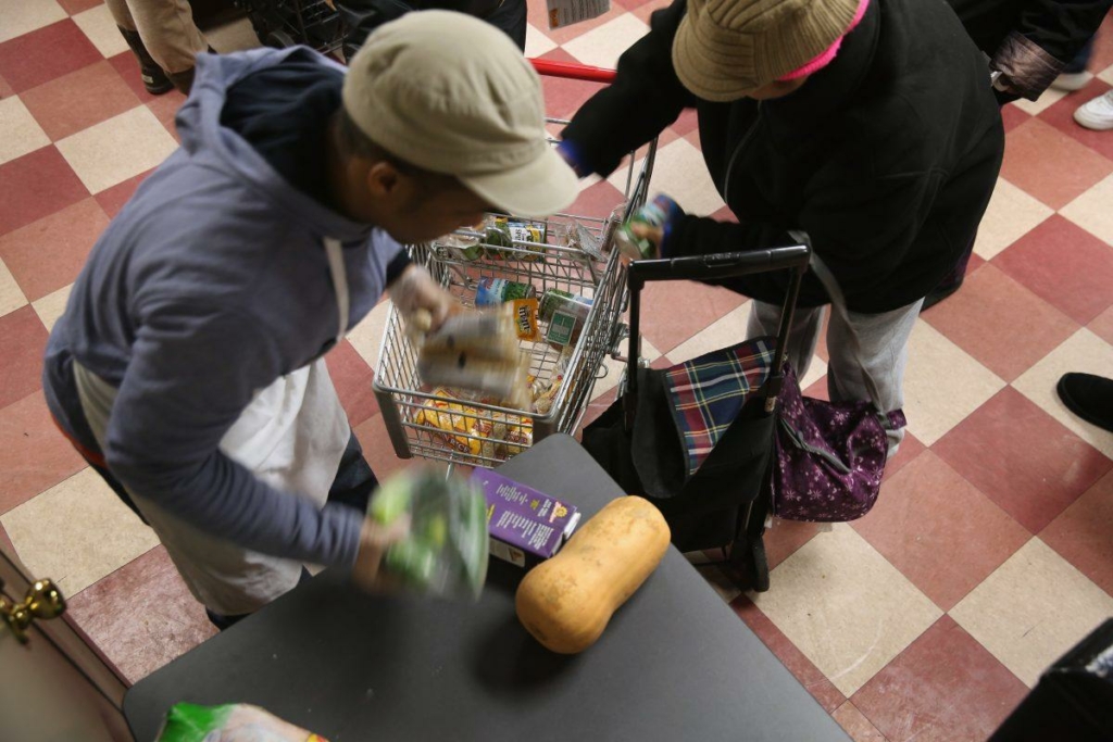 Cư dân Harlem đóng gói hàng bách hóa miễn phí tại Ngân hàng Thực phẩm Thành phố New York vào 11/12/2013 (Ảnh: John Moore/Getty Images)