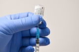 Một nhân viên dùng kim chích và lọ vaccine Pfizer-BioNTech Covid-19 để chuẩn bị một liều thuốc tại trung tâm y tế chích ngừa ở Cardiff, Nam Wales vào ngày 08/12/2020. (Ảnh của JUSTIN TALLIS/AFP từ Getty Images)