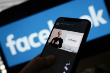 Một người đang xem Giám đốc điều hành Facebook Mark Zuckerberg ra mắt logo META ở Los Angeles vào ngày 28/10/2021 trên điện thoại thông minh. (Ảnh: Chris Delmas / AFP qua Getty Images)