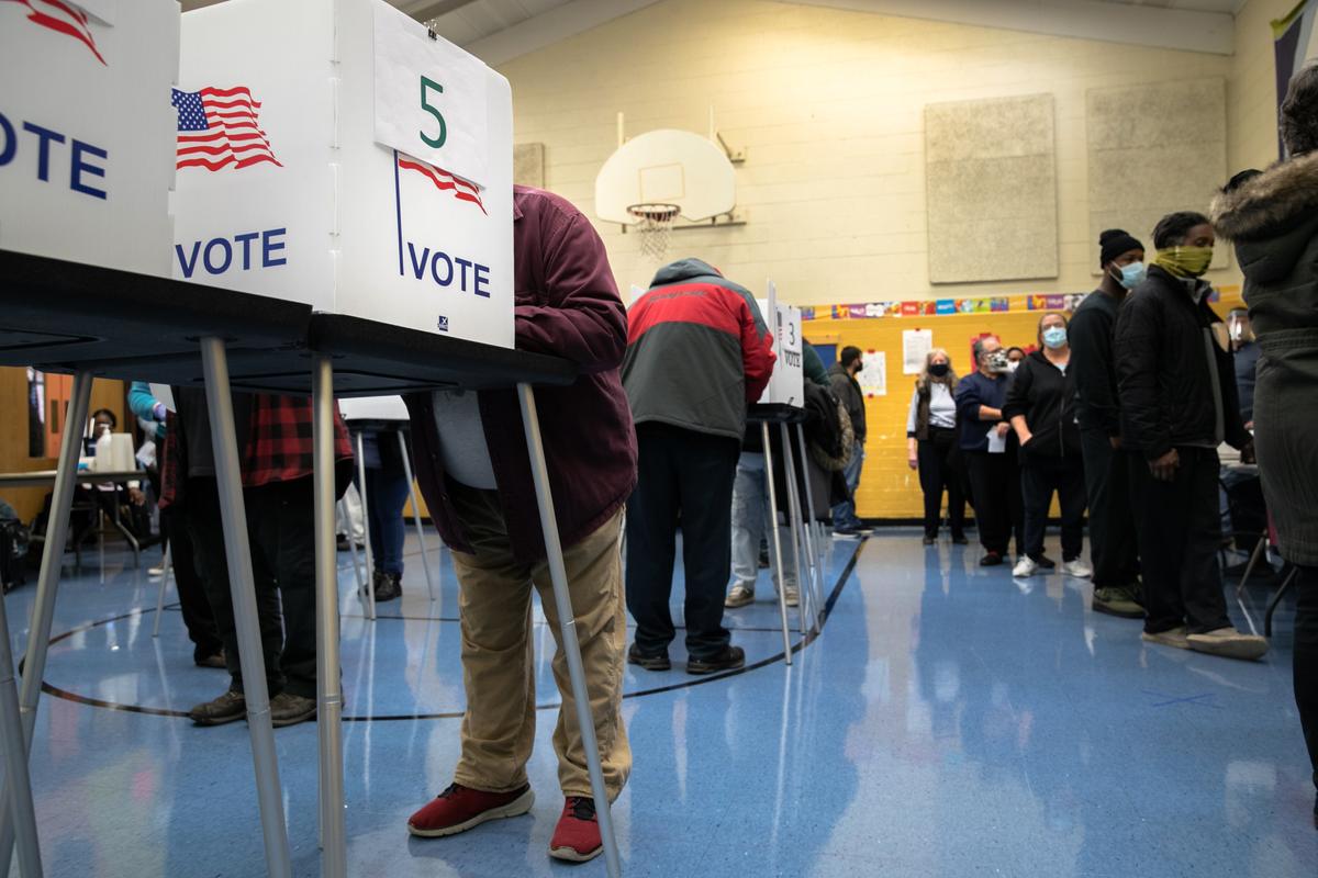 Cử tri đang điền phiếu bầu của họ tại một phòng tập thể dục của trường học ở Lansing, Michigan, vào ngày 03/11/2020. (Ảnh: John Moore/Getty Images)