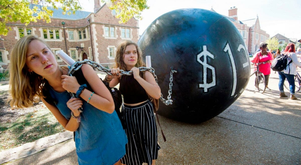 Các sinh viên tham gia một cuộc biểu tình kéo một mô hình “quả tạ và dây xích sắt,” tượng trưng cho khoản nợ sinh viên trị giá 1.4 ngàn tỷ USD vào thời điểm đó, tại Đại học Washington ở St. Louis, Minnesota, ngày 09/10/2016. (Ảnh: Paul J. Richards/AFP qua Getty Images)