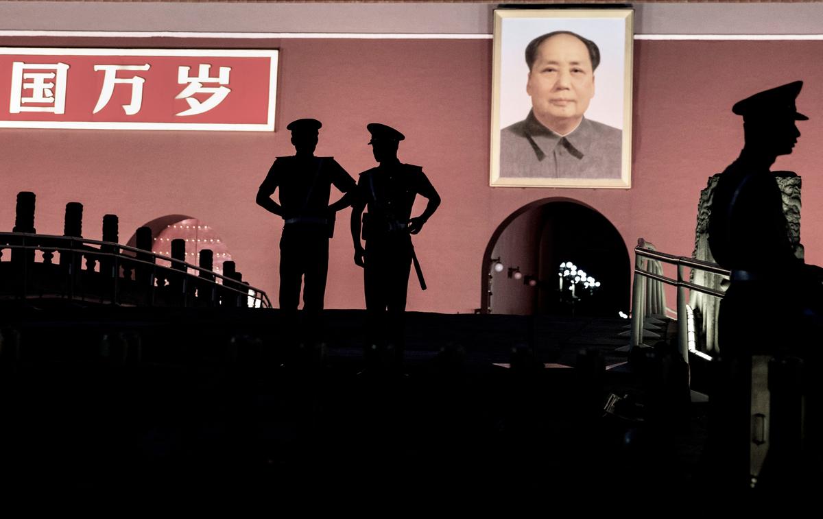 Cảnh sát bán quân sự Trung Quốc đứng gác bên dưới bức chân dung của cố lãnh đạo Mao Trạch Đông phía trước Tử Cấm Thành tại Quảng trường Thiên An Môn vào ngày 04/06/2014 tại Bắc Kinh, Trung Quốc. Hai mươi lăm năm trước, vào ngày 04/06/1989, quân đội Trung Quốc đã đàn áp những người biểu tình đòi dân chủ và trong các cuộc đụng độ sau đó, rất nhiều người đã bị thiệt mạng và bị thương. (Ảnh: Do Kevin Frayer chụp/Getty Images)