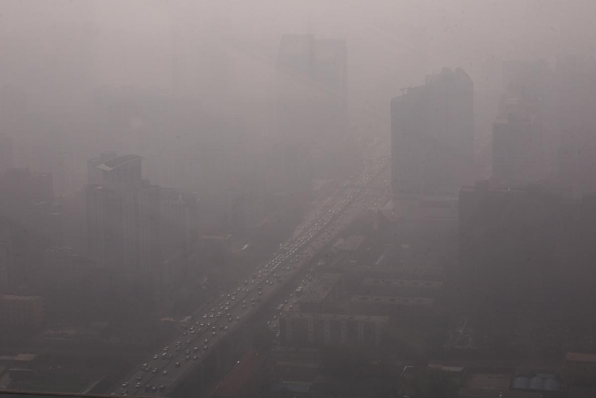 Xe cộ di chuyển trên một con đường ở Khu Thương mại Trung tâm (CBD) của Bắc Kinh hôm 01/11/2023, khi thành phố bị bao phủ trong sương mù dày đặc. (Ảnh: Tingshu Wang/Reuters)