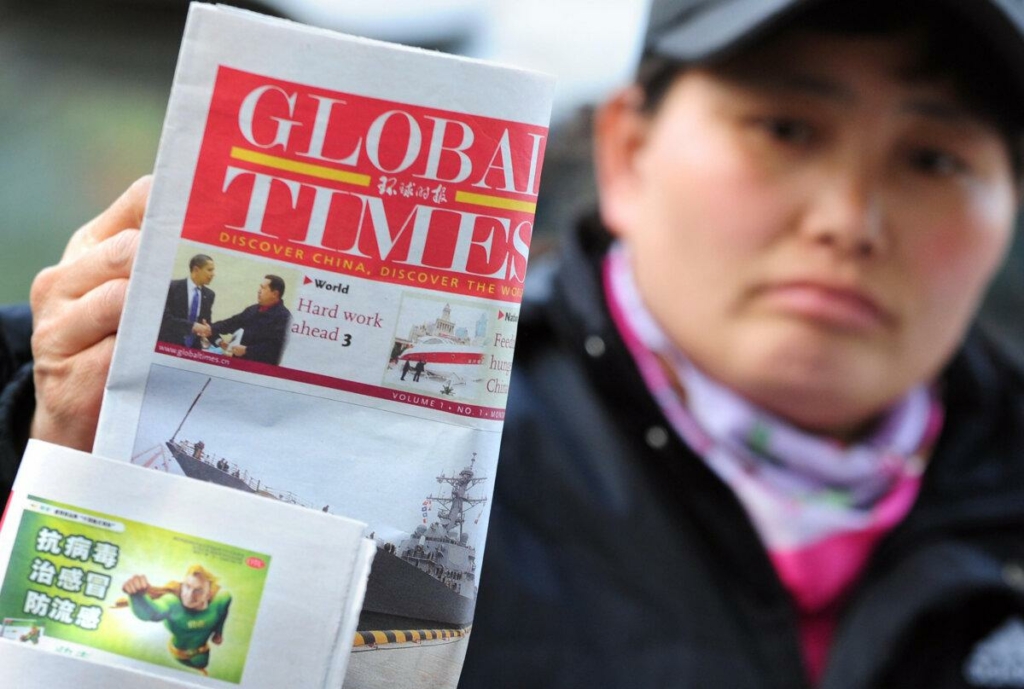 Một người bán báo đặt một tờ báo của Thời báo Hoàn Cầu, do Nhân dân Nhật báo, cơ quan ngôn luận của Đảng Cộng sản cầm quyền xuất bản, để trưng bày trên sạp báo của cô ở Bắc Kinh vào ngày 20/04/2009. (Ảnh: Frederic J. Brown/AFP qua Getty Images)