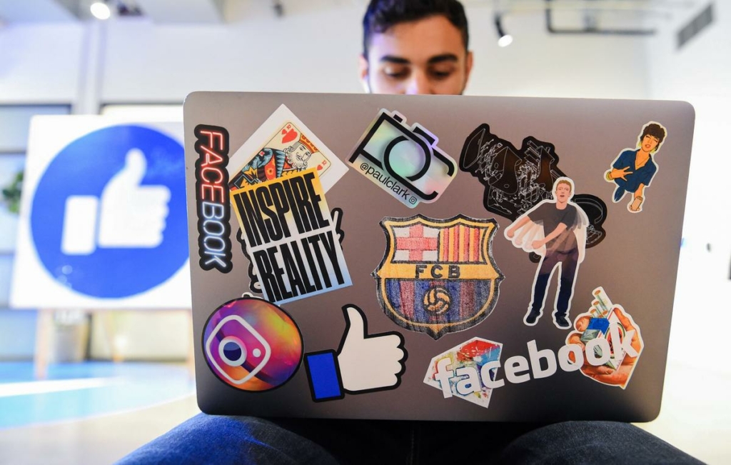 Nhân viên Facebook Mohamed Almari làm việc trên chiếc máy điện toán xách tay được trang trí bằng nhiều nhãn dán Facebook khác nhau của mình tại khuôn viên trụ sở công ty của công ty ở Menlo Park, California, vào ngày 23/10/2019. (Ảnh: Josh Edelson/AFP qua Getty Images)