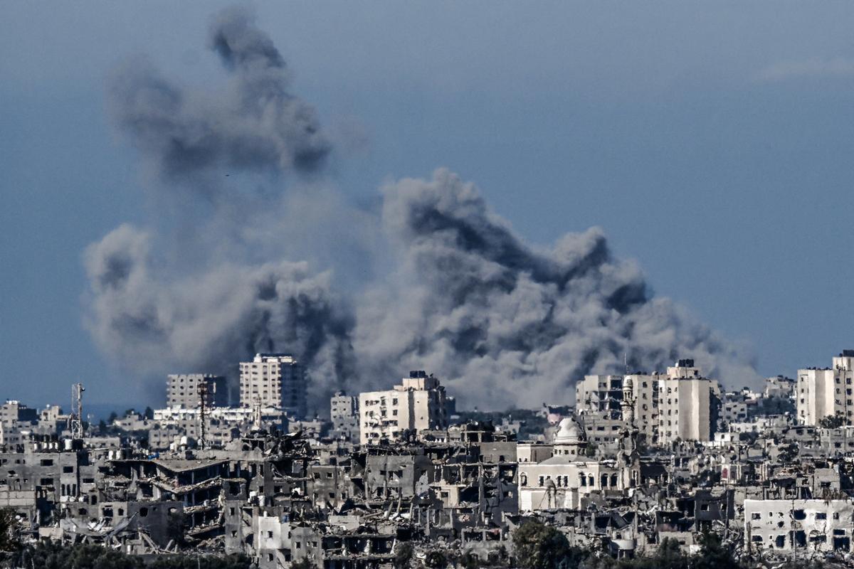 Khói bốc lên phía sau những tòa nhà bị phá hủy ở phía tây bắc Dải Gaza, nhìn từ phía biên giới Israel hôm 21/10/2023. (Ảnh: Aris Messinis/AFP qua Getty Images)
