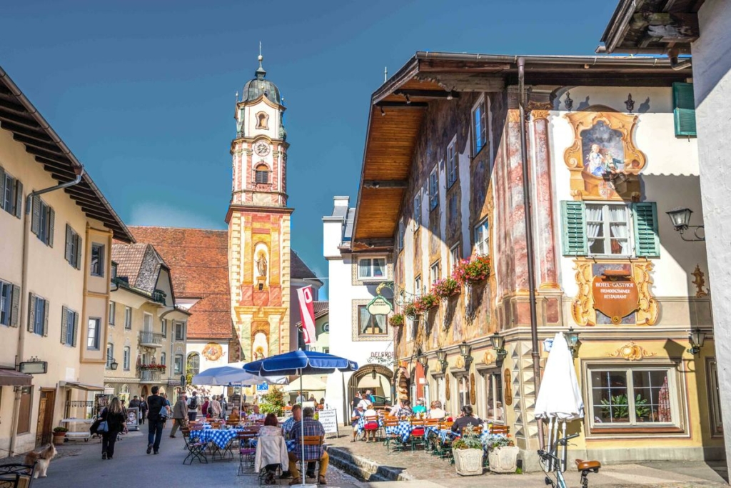 Những người đi chợ tận hưởng một ngày đẹp trời tại Obermarkt ở Mittenwald, Đức. (Ảnh: Sina Ettmer Photography/Shutterstock)