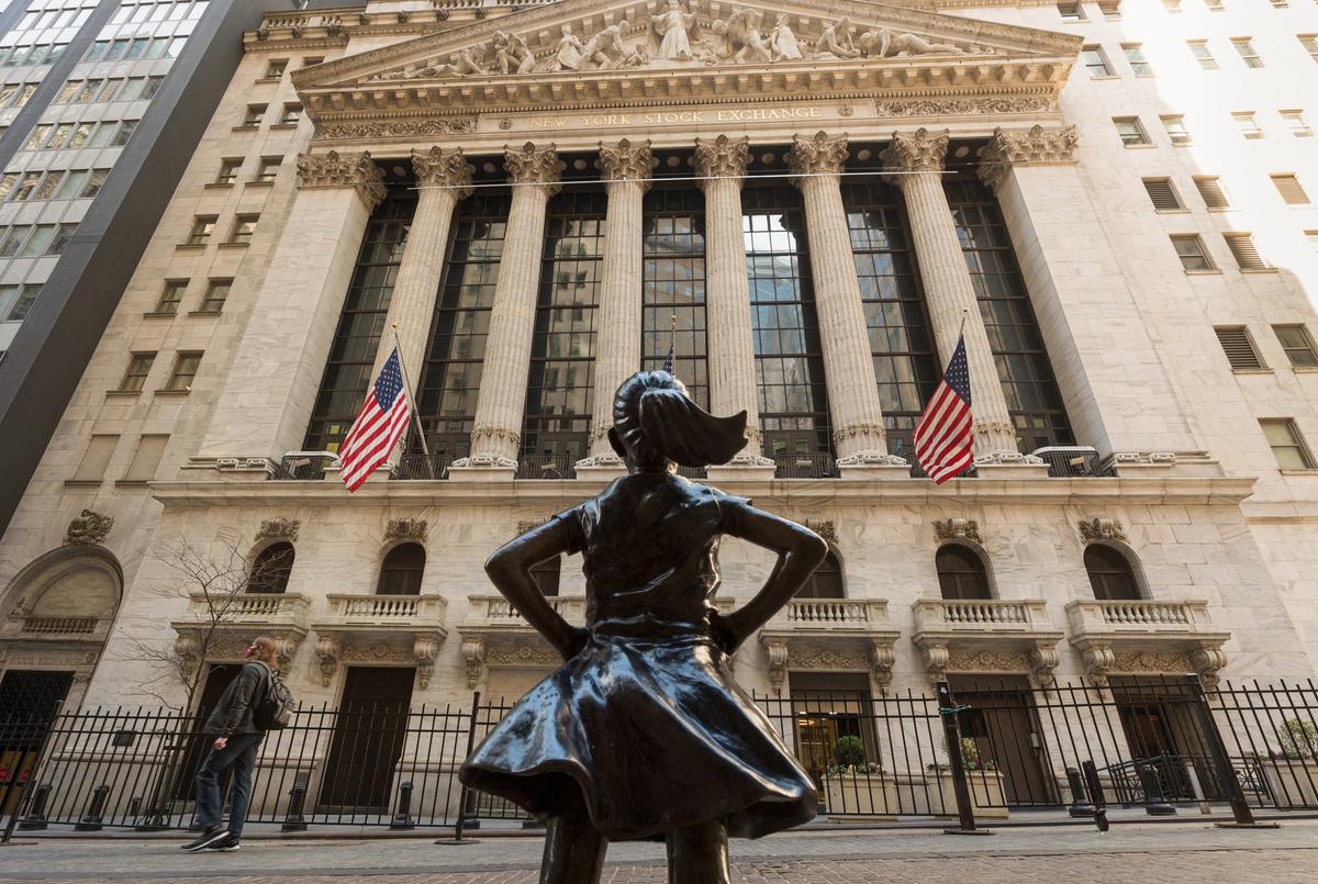 Sở Giao dịch Chứng khoán New York và bức tượng ‘Cô gái không sợ hãi’ được nhìn thấy trên Wall Street ở thành phố New York hôm 23/03/2021. (Ảnh: Angela Weiss/ AFP qua Getty Images)