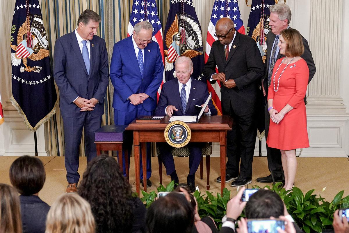 Bên cạnh là các nhà lập pháp, Tổng thống Joe Biden (ở giữa) mỉm cười sau khi ký Đạo luật Giảm Lạm Phát năm 2022, tại Tòa Bạch Ốc ở Hoa Thịnh Đốn hôm 16/08/2022. (Ảnh: Mandel Ngan/AFP/Getty Images