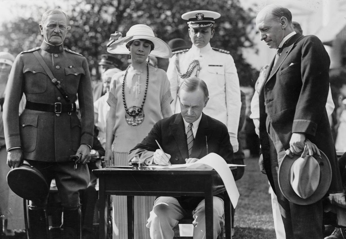 Tổng thống đương thời Calvin Coolidge ký dự luật tài trợ cho Cơ quan Cựu chiến binh, tại Tòa Bạch Ốc ở Hoa Thịnh Đốn vào ngày 05/06/1924. (Ảnh: Tư liệu Công cộng)