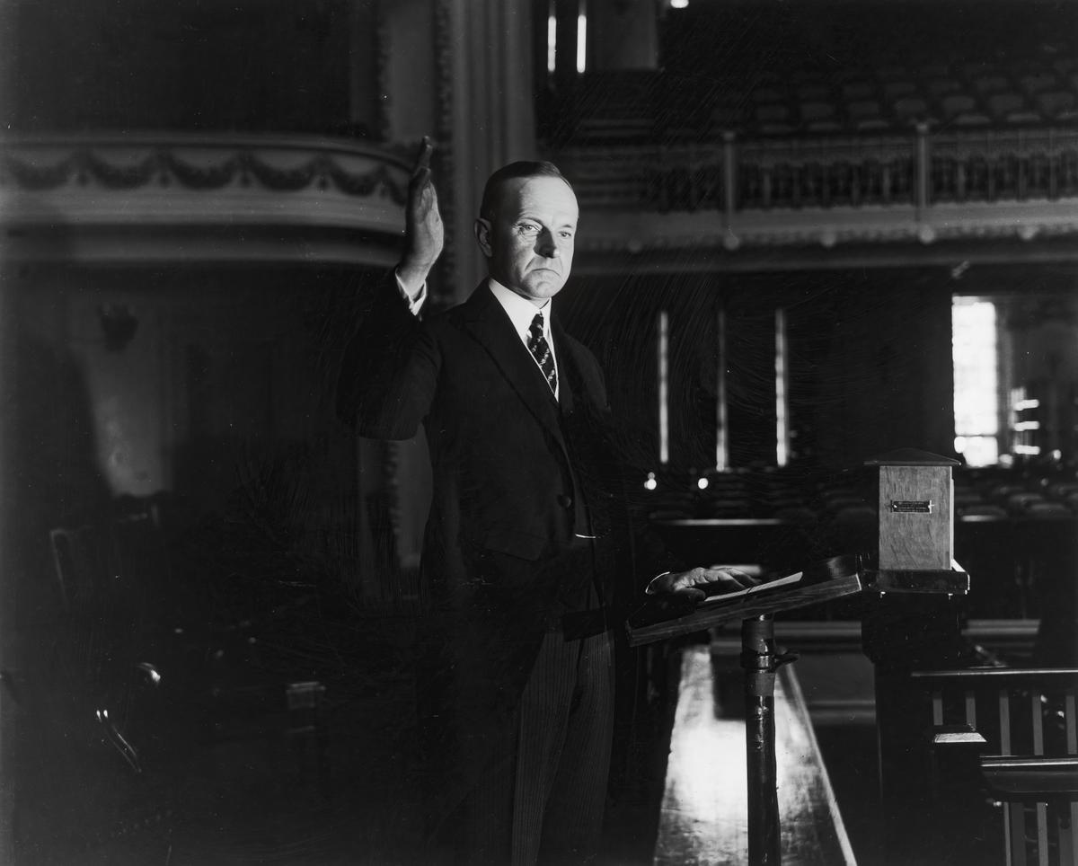 Tổng thống Coolidge giơ tay phải trong buổi lễ tuyên thệ ở Thủ đô Hoa Thịnh Đốn. (Ảnh: Hulton Archive/Getty Images)