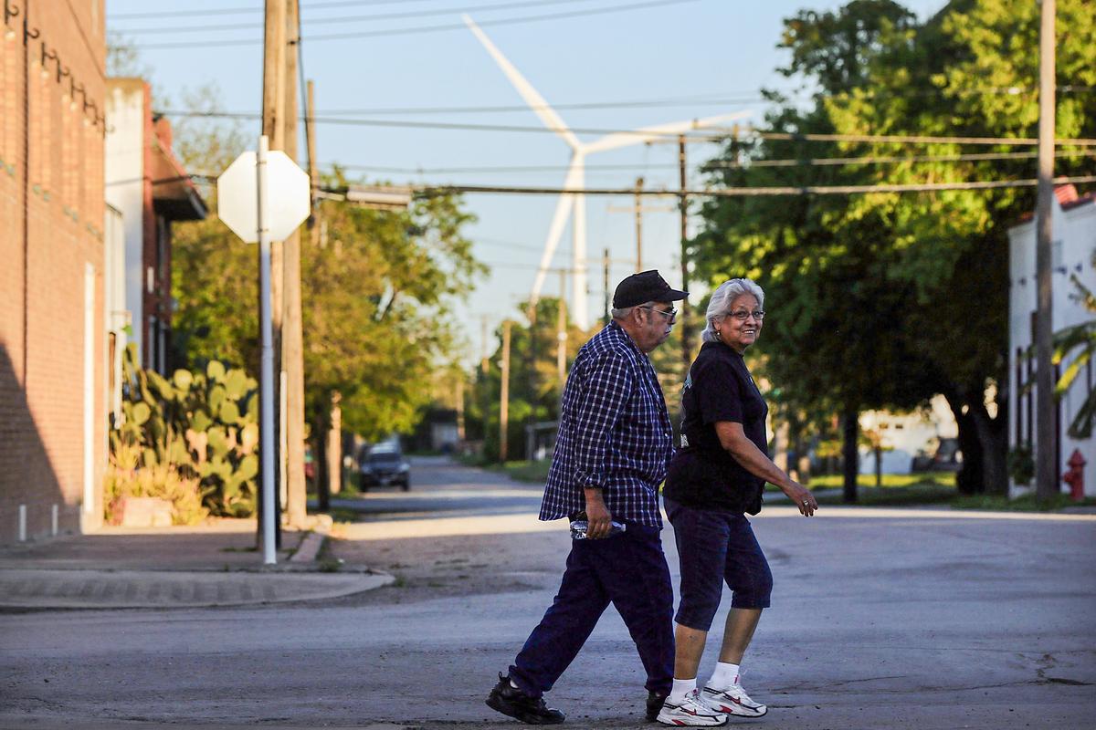 Một tuabin gió ở phía sau một cặp đôi đang băng qua đường ở Taft, Texas, vào ngày 27/03/2015. (Ảnh: Spencer Platt/Getty Images)
